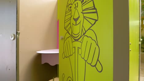Behind-the-doors-adorned-with-a-lion's-image-lies-a-children's-bathroom,-inviting-and-playful-in-design