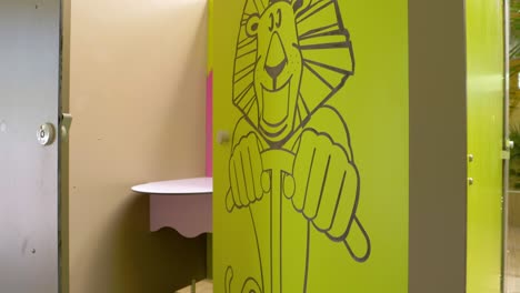 behind the doors adorned with a lion's image lies a children's bathroom, inviting and playful in design