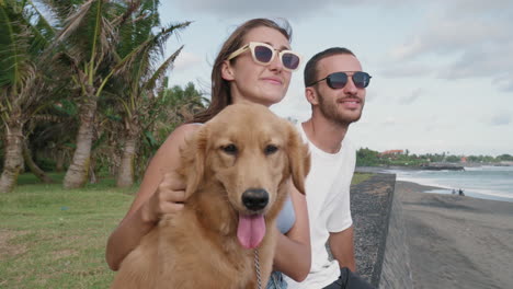 pareja y perro en la playa ventosa