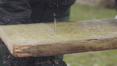 Handheld-slow-motion-shot-of-female-woodworker-cutting-a-board-with-a-jigsaw-from-beneath