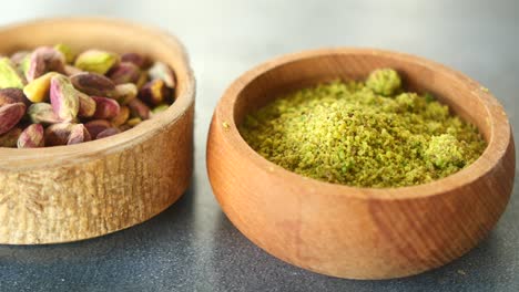 pistachios and pistachio powder in wooden bowls