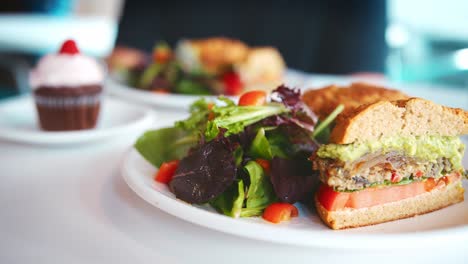 Waitress-Placing-Vegan-Sandwich-On-Table-In-Coffee-Shop