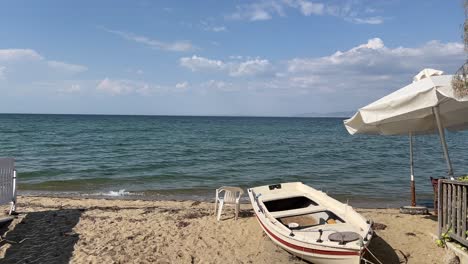 perea beach with umbrella and abandoned boat close to thessaloniki in 4k with aegean sea in the background