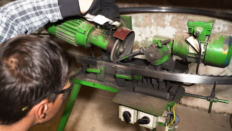 el ingeniero ajusta la máquina afiladora automática de sierras de banda en un antiguo taller