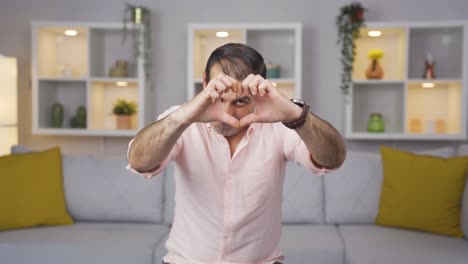 Man-making-heart-sign-at-camera.