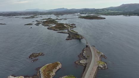 Famous-Atlantic-Ocean-road-in-Norway---Summer-aerial-with-Storseisundet-bridge-and-road-surrounded-by-windy-ocean