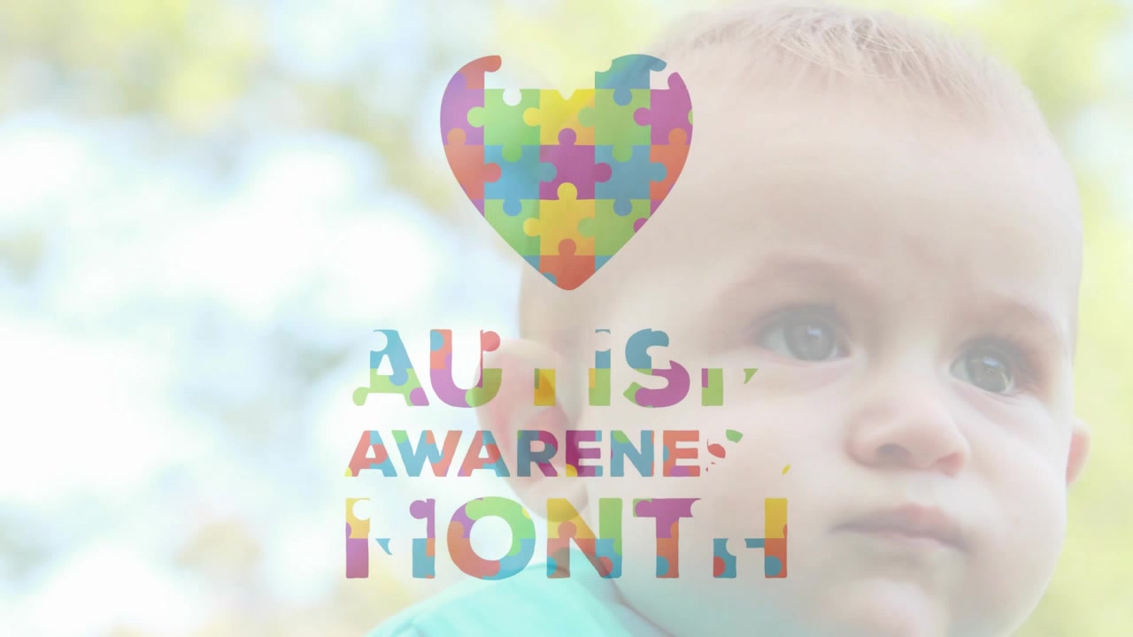Bebé niño observando cómo se inician los fotogramas y un corazón de piezas de rompecabezas se ensambla sobre su cabeza para la concienciación sobre el autismo.