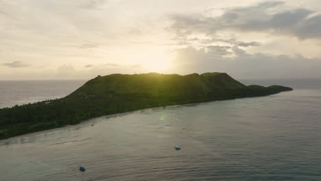 island silhouette at dusk with warm sky and soft reflection on ocean surface