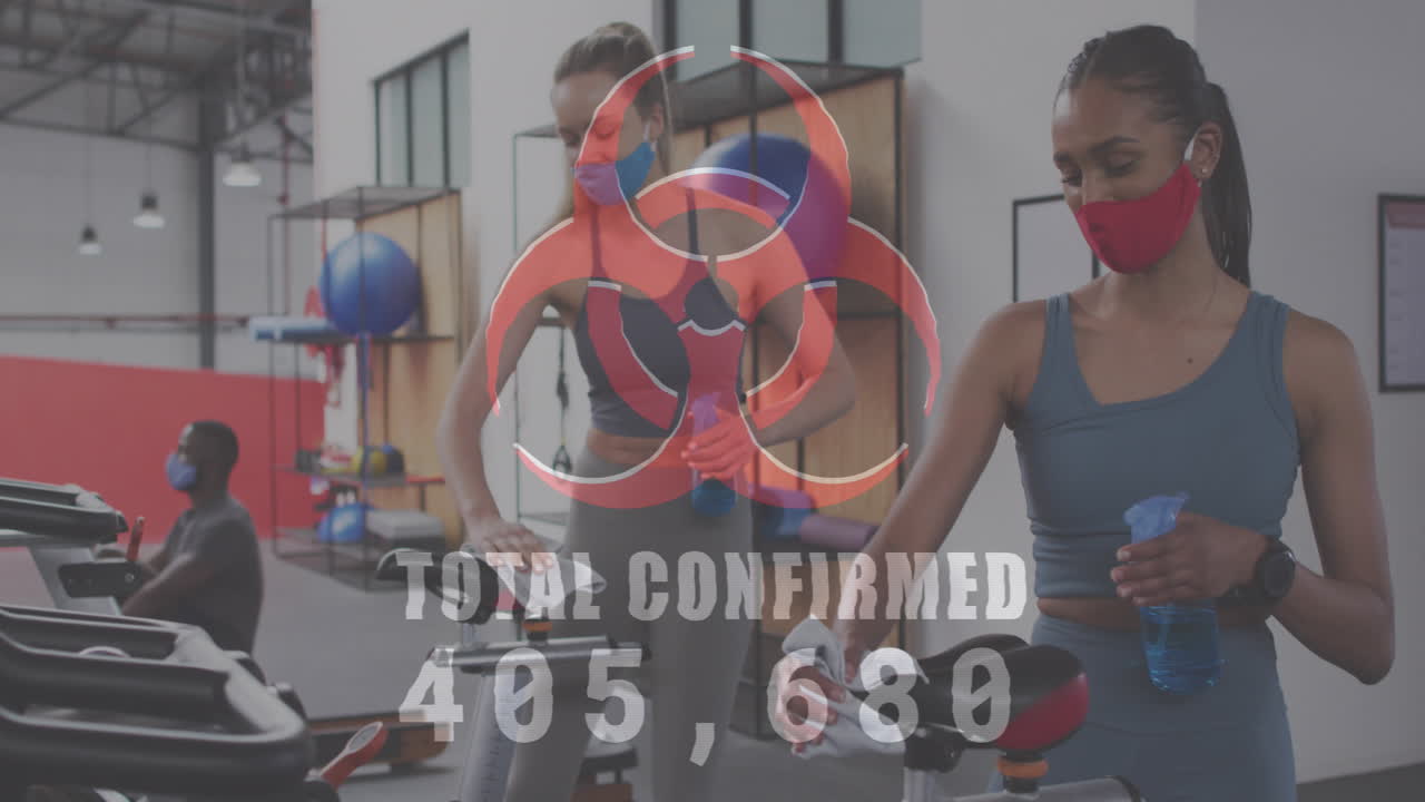 el símbolo de peligro biológico destaca los riesgos de covid-19 en la limpieza del gimnasio por parte de las mujeres.