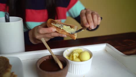 un cuenco de mantequilla cremosa que se extiende uniformemente sobre una rebanada de pan tostado