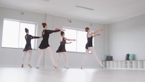 Caucasian-female-ballet-dancers-practicing-a-dance-routine-during-a-ballet-class