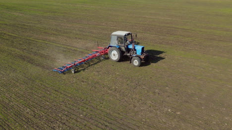 Der-Traktor-Zieht-Ein-Landwirtschaftliches-Gerät-Zum-Eggen-Des-Landes