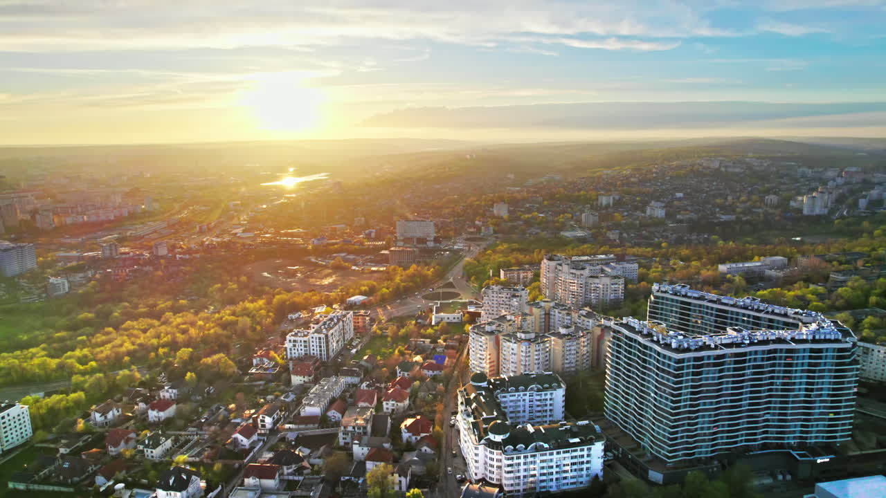 Vista aérea de drone de Chisinau ao pôr do sol, Moldávia. Bairro residencial com vários edifícios, áreas verdes e estradas com carros.