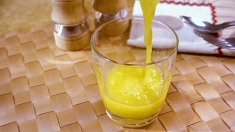 Orangensaft-In-Ein-Glas-Gießen,-Das-Morgendliche-Frühstück.-Zeitlupe-Mit-Rotierender-Kamerafahrt.