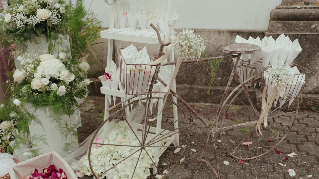 Decorative vintage bicycle with basket of flowers at wedding venue steps