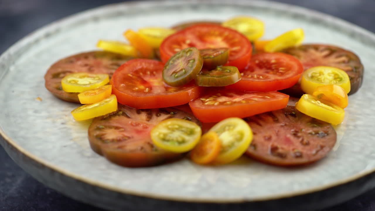 Shot Of Tomatoes On Plate Rotating. Plate Of Healthy Organic Tomatoes, Healthy Vegetarian Vegan Raw Salad. Plant Based Raw Food Meal.