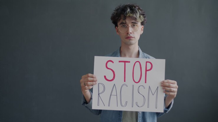Giovane uomo che regge un cartello di protesta antirazzista