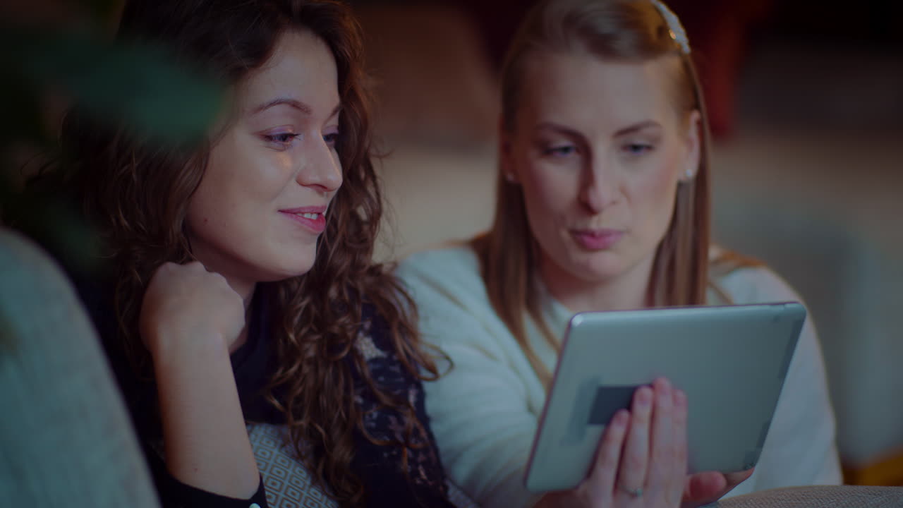 Two Girls Doing Online Shopping On Digital Tablet