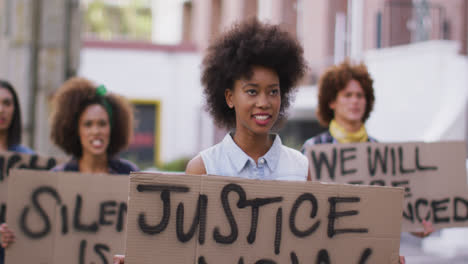 diverse group of men and women holding placards shouting during protest