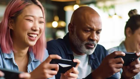 a diverse group engaged in interactive gaming: a smiling young woman and a focused older man enjoying mobile games together in a modern cafe setting