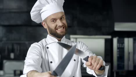 Chef-posing-with-knives-at-kitchen.-Chef-man-having-fun-with-tools-at-kitchen.