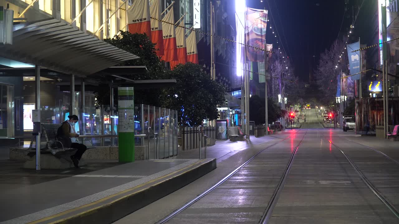 최전선 의료 종사자는 전 세계 코로나 바이러스가 발생하는 동안 밤에 대중 교통을 기다립니다.