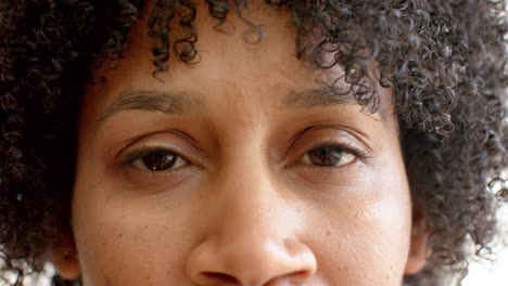 a biracial woman with curly hair is looking forward
