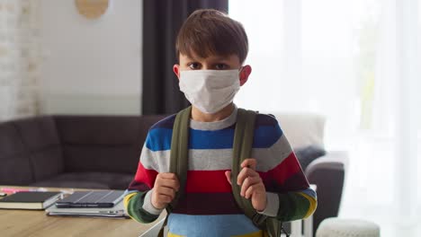 Handheld-video-of-portrait-schoolboy-in-protective-face-mask