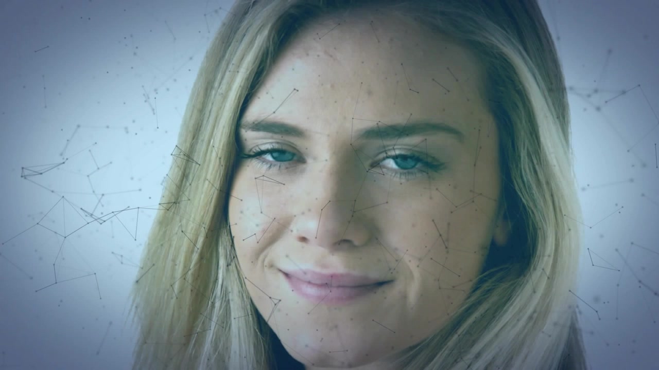 Donna che chiude gli occhi sorridendo e li riapre mentre un'interfaccia digitale si muove sul suo viso, mostrando serenità tecnologica.