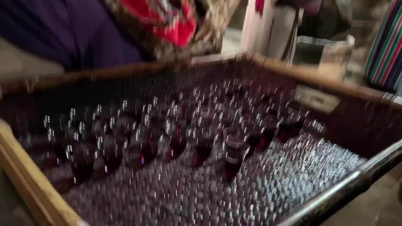 Person Serving Wine in Small Glasses at a Religious Ceremony