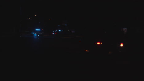 police scene, street taped off with cars with blue lights