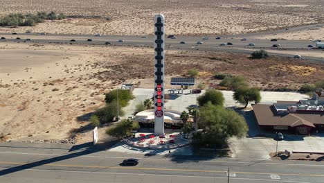 aerial drone descending over world's tallest thermometer landmark attraction in baker, recording death valley, california