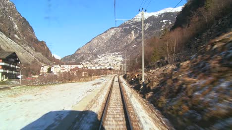una toma de pov desde la parte delantera de un tren que se mueve a través de una región montañosa