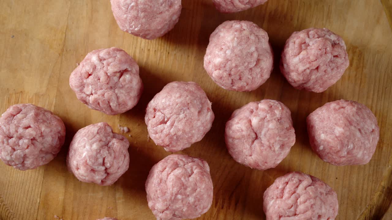 나무로 만든 절단판 위에 있는 생 고기 어리는 천천히 회전합니다.