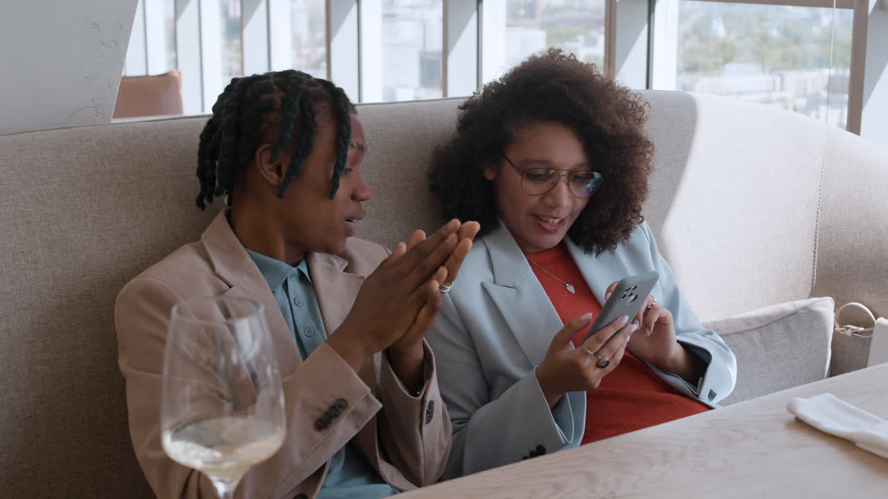 Two people having a conversation in a restaurant.