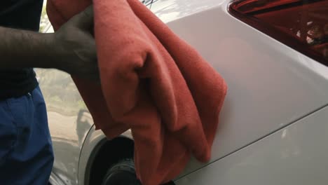 Close-up-of-a-male-wiping---drying-a-white-car