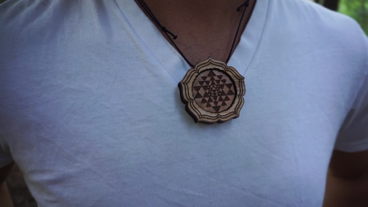 mostrando un hermoso collar de madera que una melena le hizo en el festival