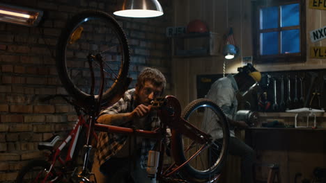 two men repairing a bicycle in a garage