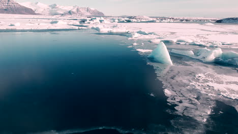 jökulsárlón iceland aerial circling shot of large glaciers sitting in ocean blue water