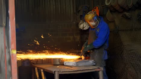 Male-worker-using-grinder-machine-in-workshop-4k