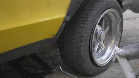 a man sprays an aerosol into a loose tire and burns it