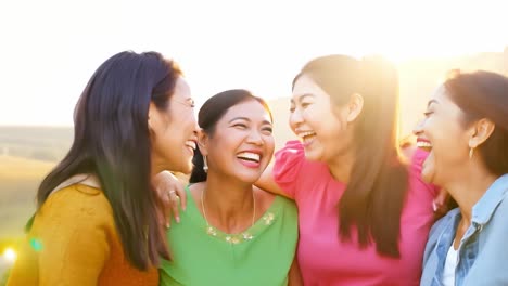 four women laughing together outdoors