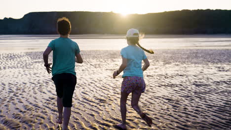 niños corriendo en la playa al atardecer