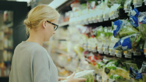 woman chooses fresh vegetables in the organic department of the supermarket 4k video