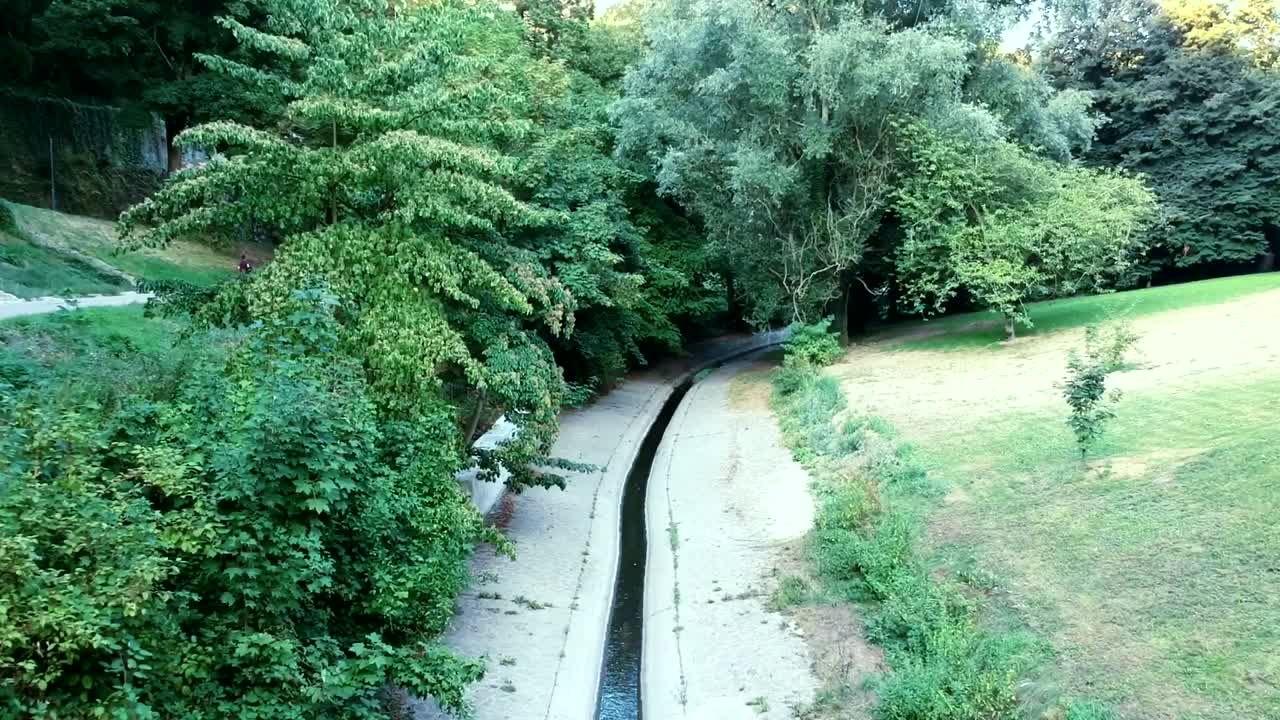 vista aérea del agua del pequeño canal en la naturaleza del valle de petrusse con corredor atleta