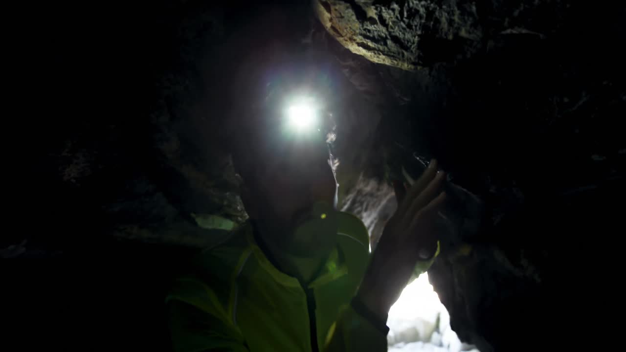 excursionista masculino explorando una cueva oscura 4k