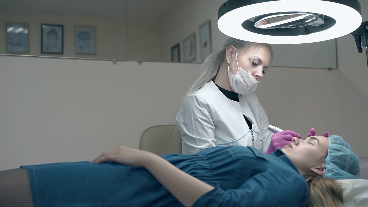 una esteticista experimentada aplica maquillaje permanente para las cejas