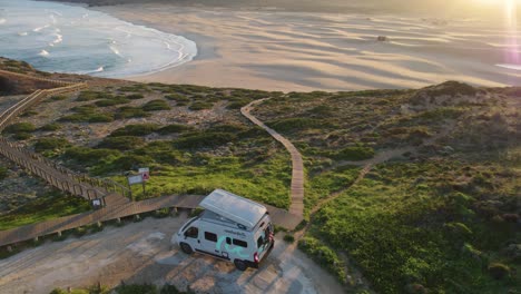 Aerial-Overhead-View-Of-Camper-Van-Parked-Up-With-View-Of-Bordeira-Beach-In-Portugal-During-Sunset
