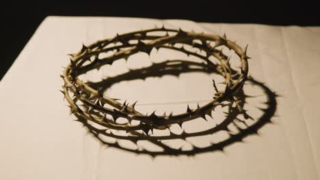 Religious-Concept-Shot-With-Close-Up-Of-Crown-Of-Thorns-On-Altar-In-Pool-Of-Light-