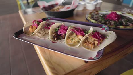 A-handheld-shot-of-a-sampler-platter-of-shrimp-and-fish-tacos-in-a-traditional-sinaloan-mexican-restaurant